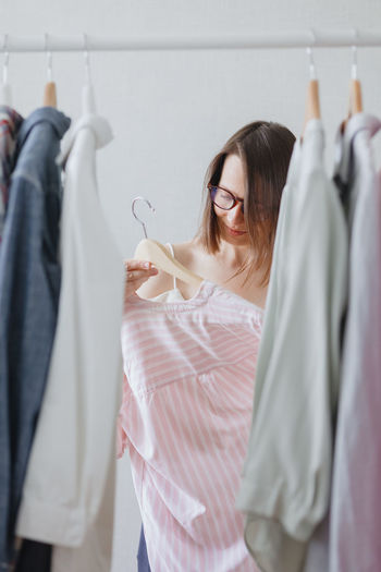 Wardrobe or laundry room. a female stylist picks up clothes or sorts them for recycling