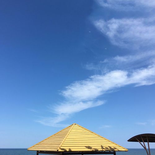 Lifeguard hut at beach against blue sky