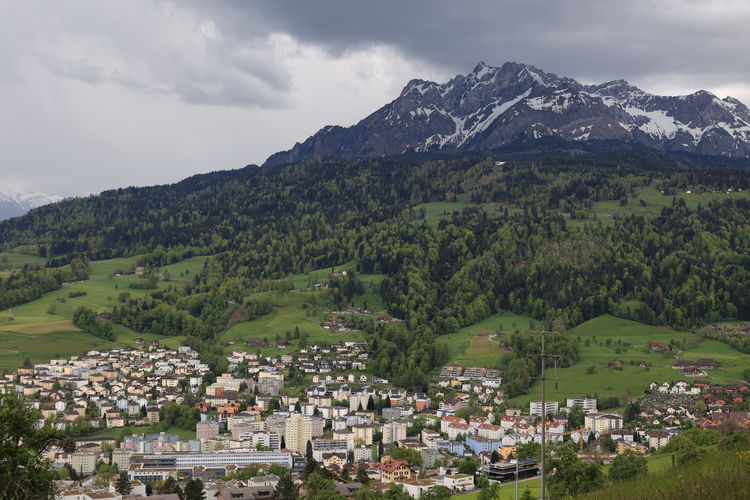 Scenic view of townscape and mountains against sky