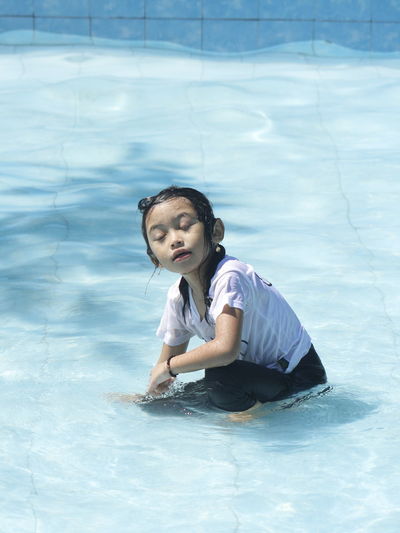 Full length of cute girl swimming in pool