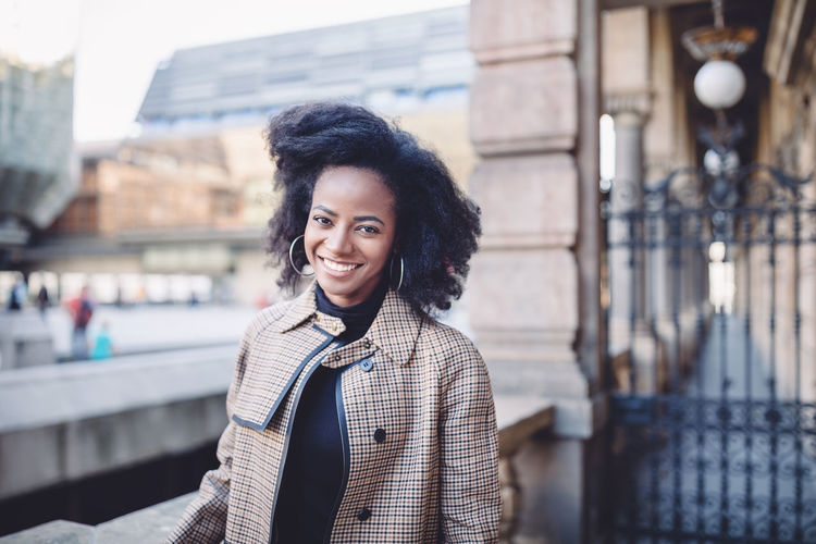 African american young woman with afro, smiling. urban street portrait.