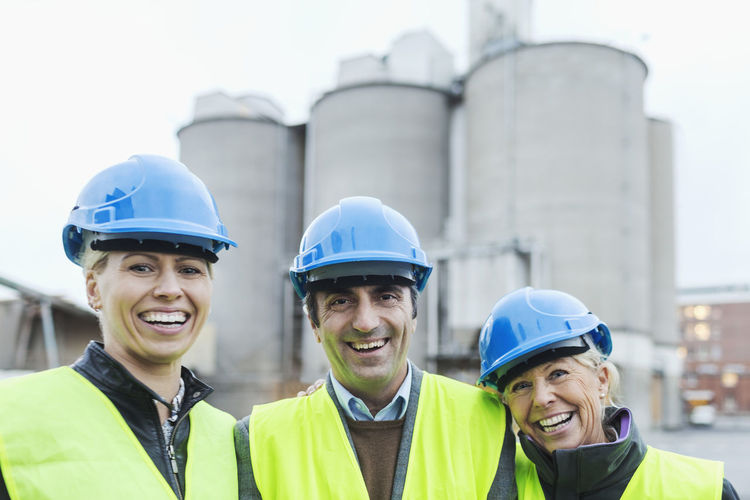 Portrait of confident workers wearing hardhats at factory