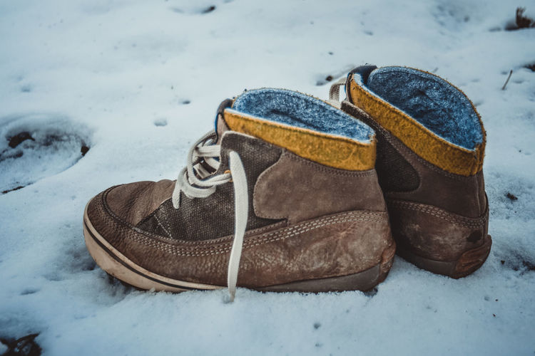 Close-up of shoes on snow covered land
