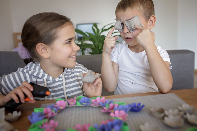 Portrait of siblings playing with toys on table