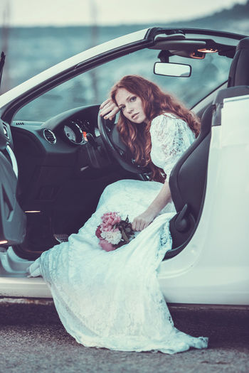 Portrait of bride sitting in car