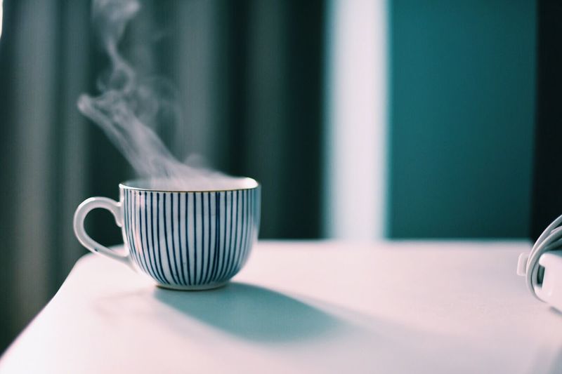 Close-up of steaming coffee cup on table