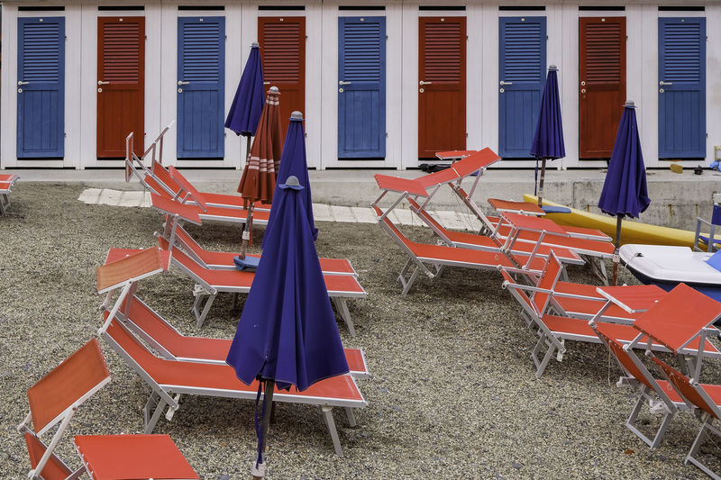 Red chairs and colorful doors near the beach in summer - rapallo, italy