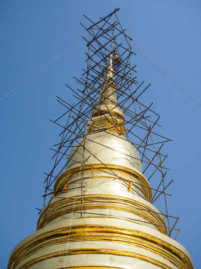Low angle view of golden dome of buddhist temple wat phra singh with scaffolding, chiang mai, thailand
