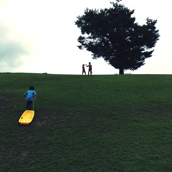People walking on field against sky