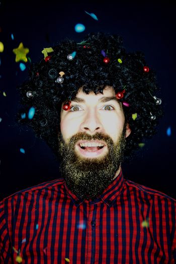 Close-up portrait of man with glitter against black background