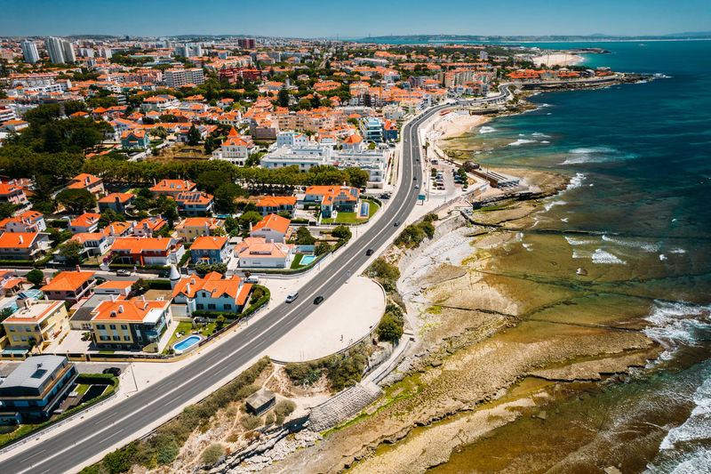 Aerial drone view of marginal avenue and coastline with parade district in greater lisbon, portugal 
