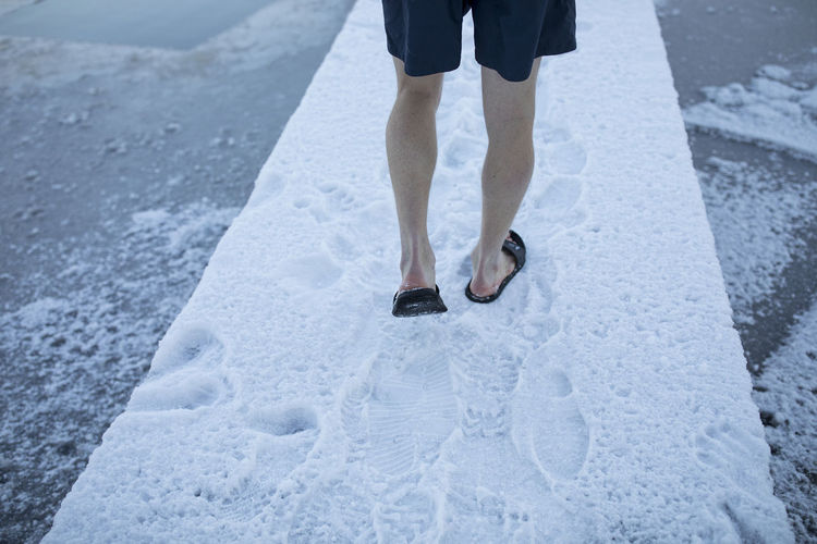Low section of wan walking at frozen lake