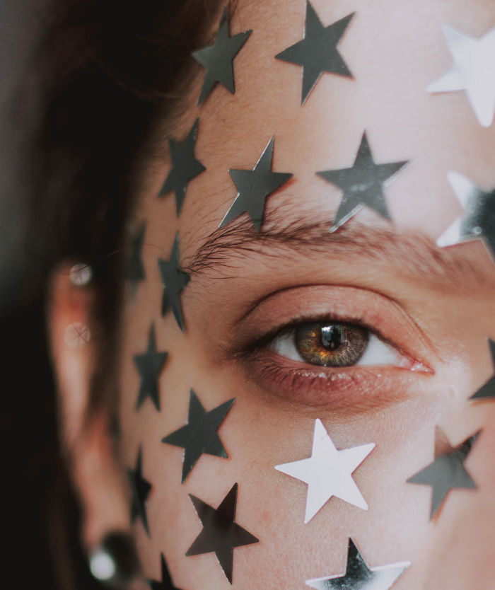Close-up portrait of young woman with stars on face