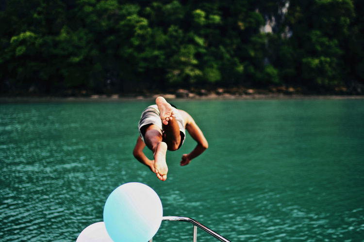 Shirtless man diving into lake