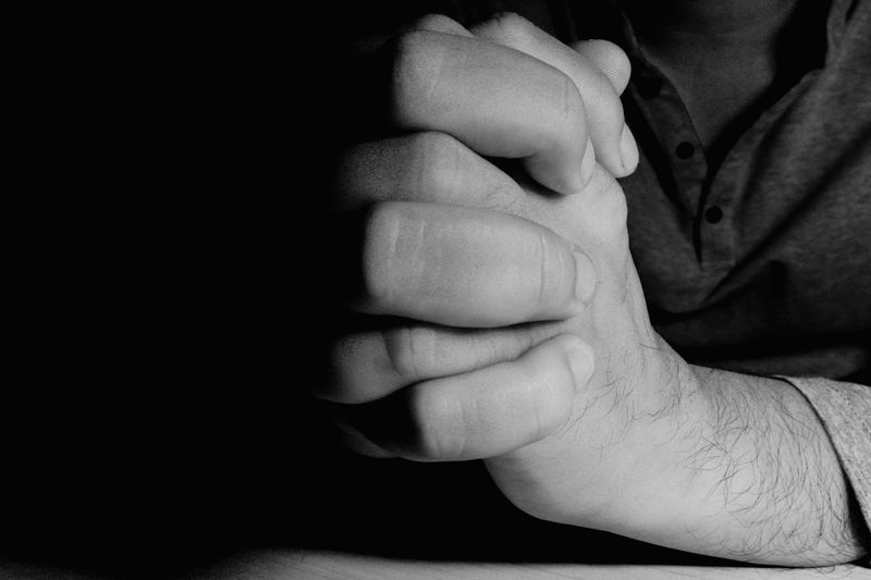 Cropped image of man with hands clasped 