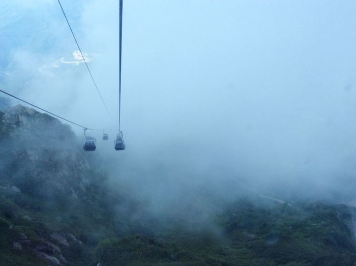 Overhead cable car against sky during foggy weather