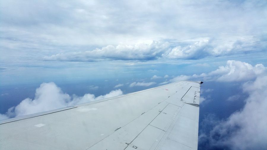 Aerial view of cloudscape over airplane wing