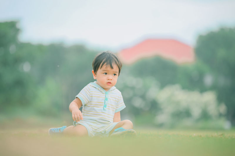 Portrait of cute girl sitting on field
