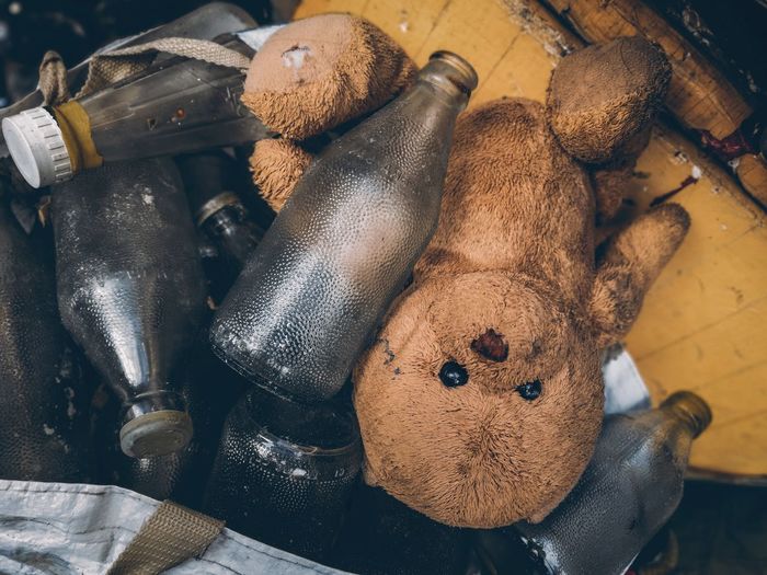 Directly above shot of abandoned teddy bear and bottles