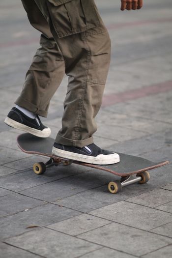 Low section of a man skateboarding on the street