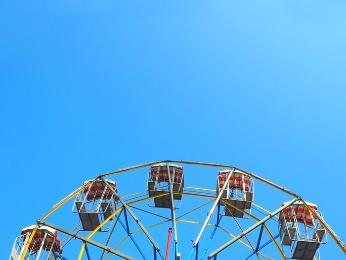 High section of ferris wheel against clear blue sky