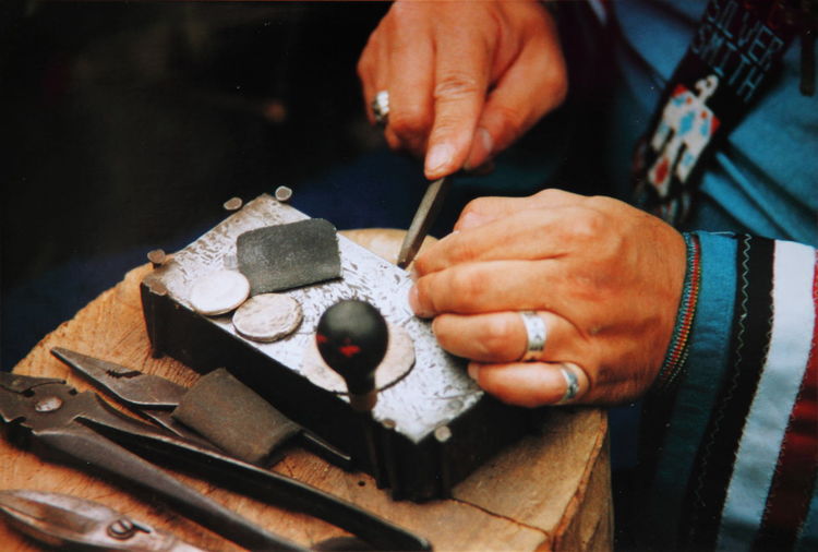 Cropped image of blacksmith hands working at shop