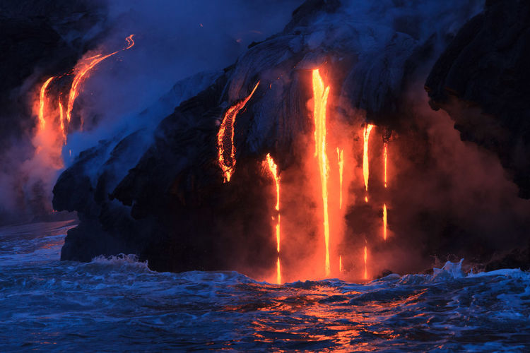 Steam rising off lava flowing into ocean