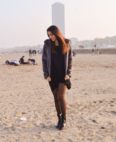 Woman standing on beach against clear sky