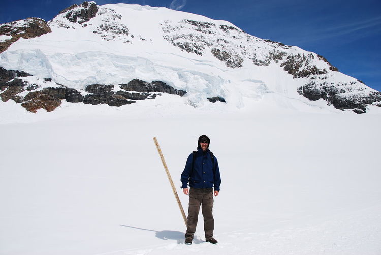 Full length of man standing on snow covered field at aletsch glacier