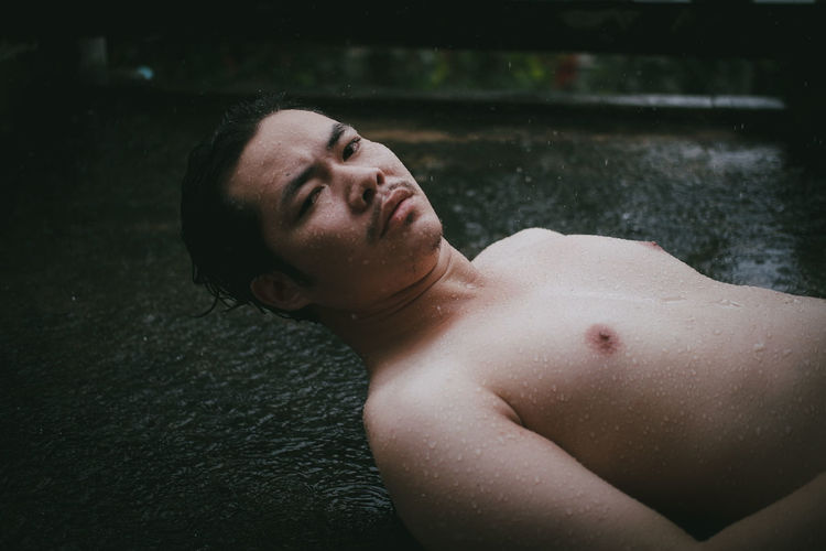 Portrait of young man lying on water