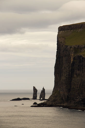 Rock formations by sea against sky