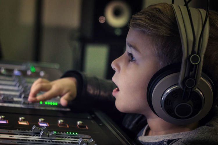Cute boy mixing music in recording studio