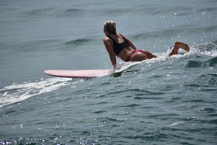 High angle view of bikini woman surfing on sea