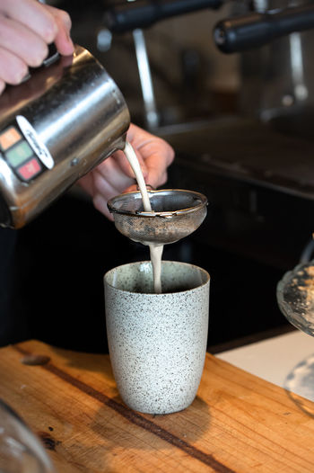 Barista pouring milk for chai latte