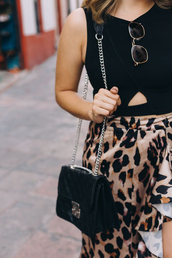 Midsection of woman holding a handbag