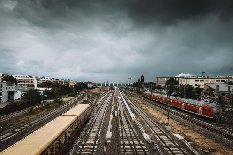High angle view of trains on railroad tracks against cloudy sky