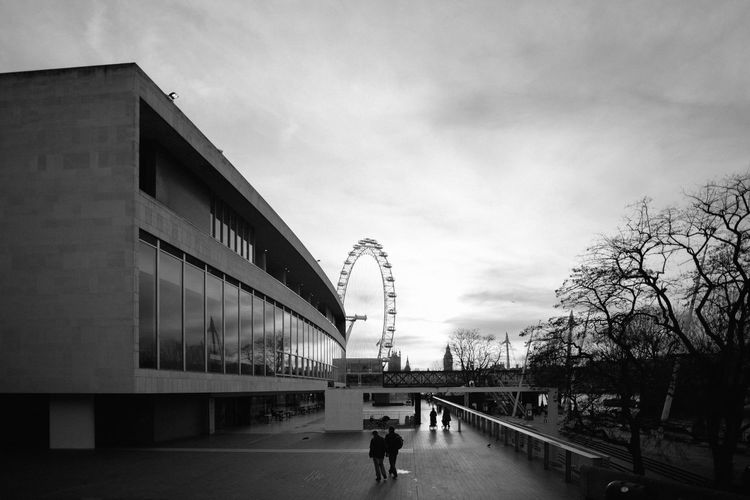 People walking in city against sky