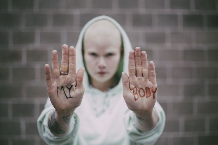 My body text written on palms of female activist