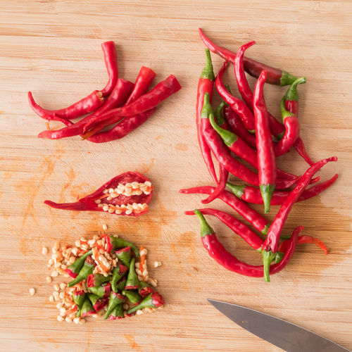 High angle view of red chili peppers on wooden table