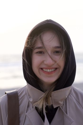 Portrait of a smiling young woman against water