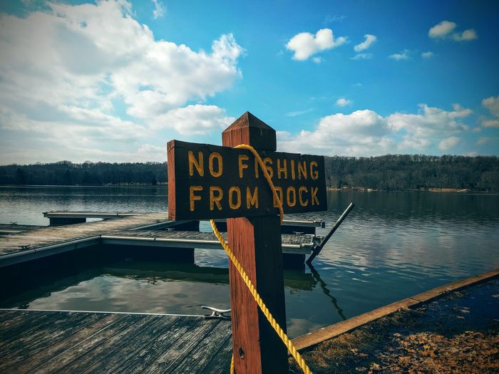 Sign board on pier at lake