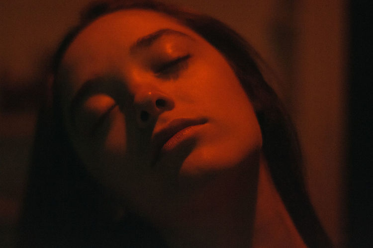 Close-up of woman sleeping in darkroom