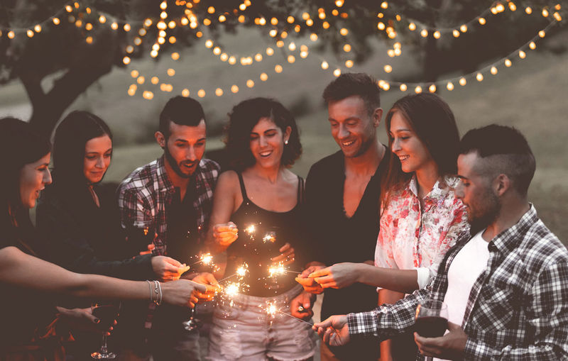 Group of people holding sparklers at night