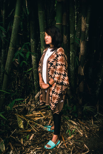 Young woman standing in forest