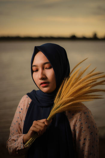 Woman in hijab holding reed