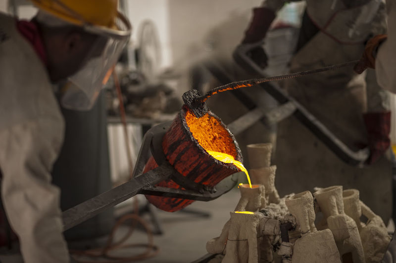 Worker casting metal in a foundry
