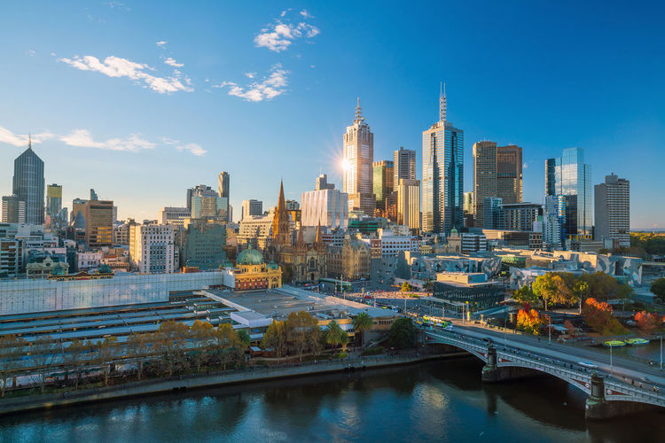 River amidst buildings in city against sky