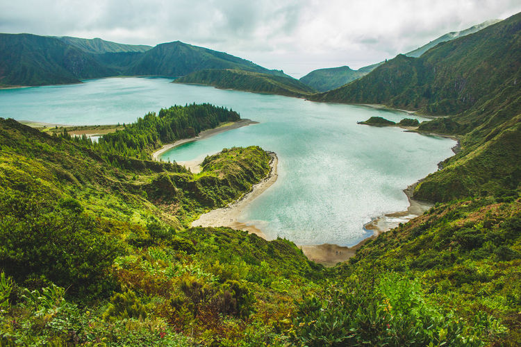 Scenic view of sea and mountains against sky