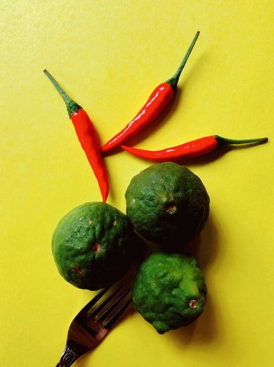 Close-up of chili peppers on yellow background