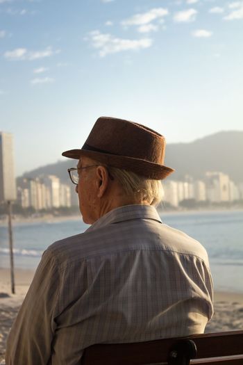 Side view of man looking at sea against sky